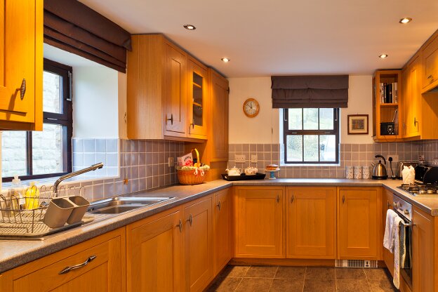 The light oak kitchen contains a fan oven, gas hob, microwave oven, dishwasher, washer dryer, and a fridge with freezer compartment.