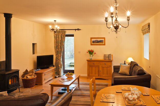 A wood burning stove and comfortable leather sofas help to make a cosy and relaxing night in.