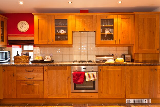 The large oak kitchen contains a fan oven, gas hob, microwave oven, dishwasher, washer dryer, and a fridge with freezer compartment.