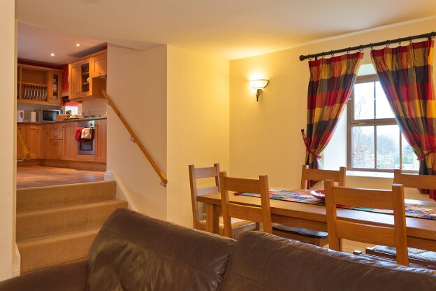 A dining area is located by the window. Steps lead to the feature window at the front of the house.